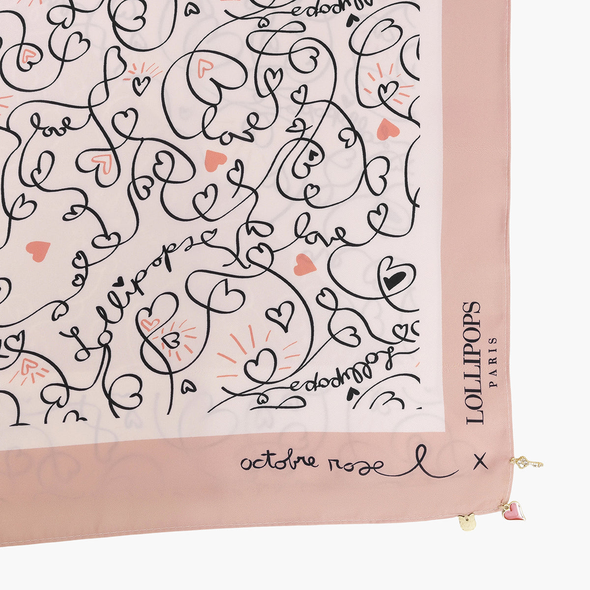 Détail de foulard rose poudré imprimé de cœurs et textes manuscrits noirs
