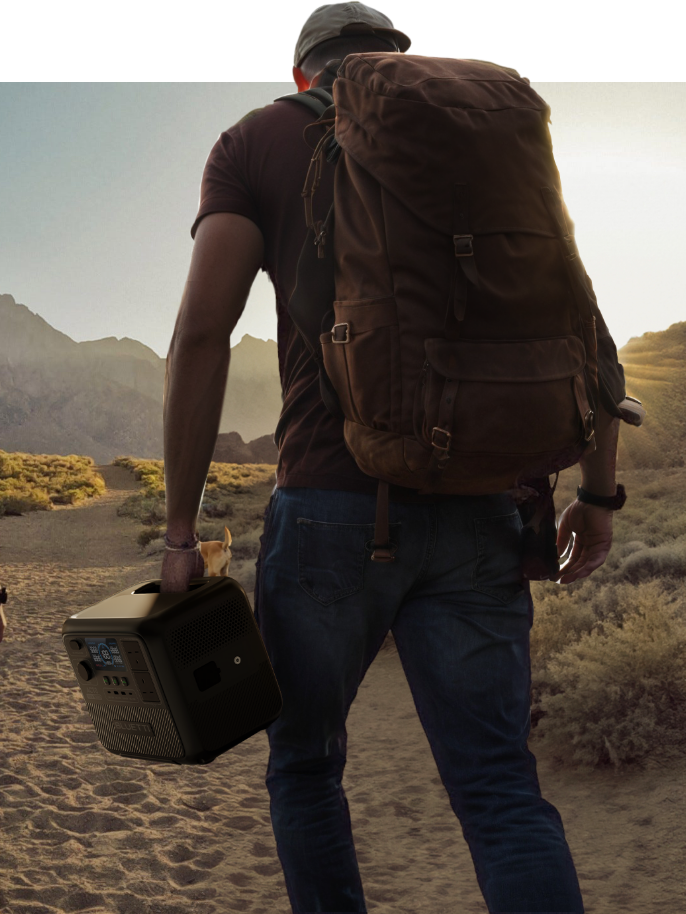 Hiker with backpack carrying portable power station walking through desert mountain landscape