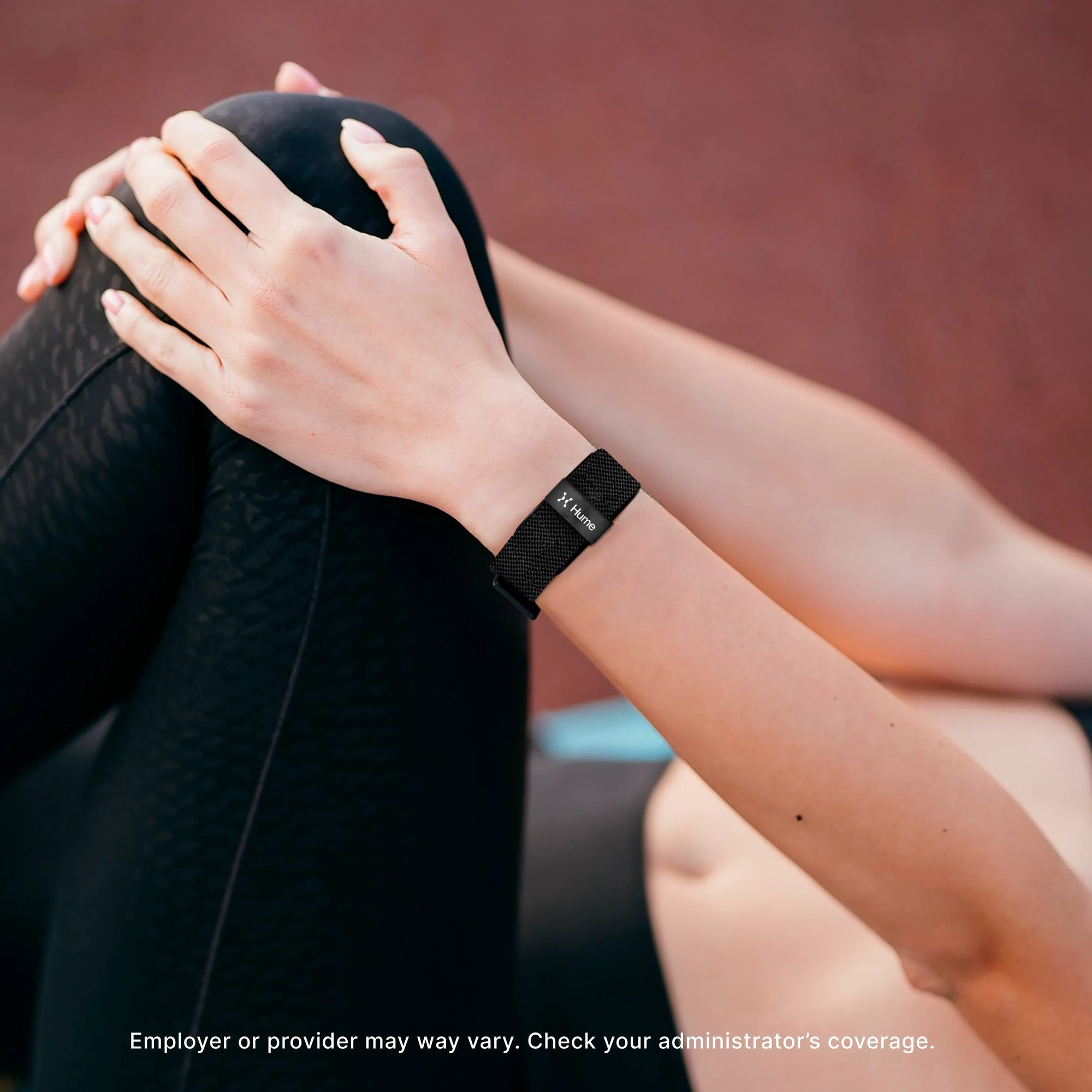 Person wearing black fitness band on wrist while holding black water bottle with eligibility disclaimer text